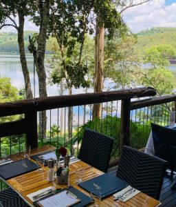A restaurant overlooking a lake with tables and chairs perfect for day tours.