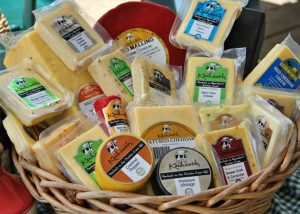 A wicker basket filled with different types of cheese.