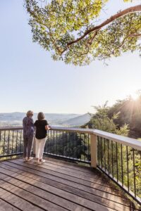 Two elderly women enjoying the Sunshine Coast Hinterland view from a deck.